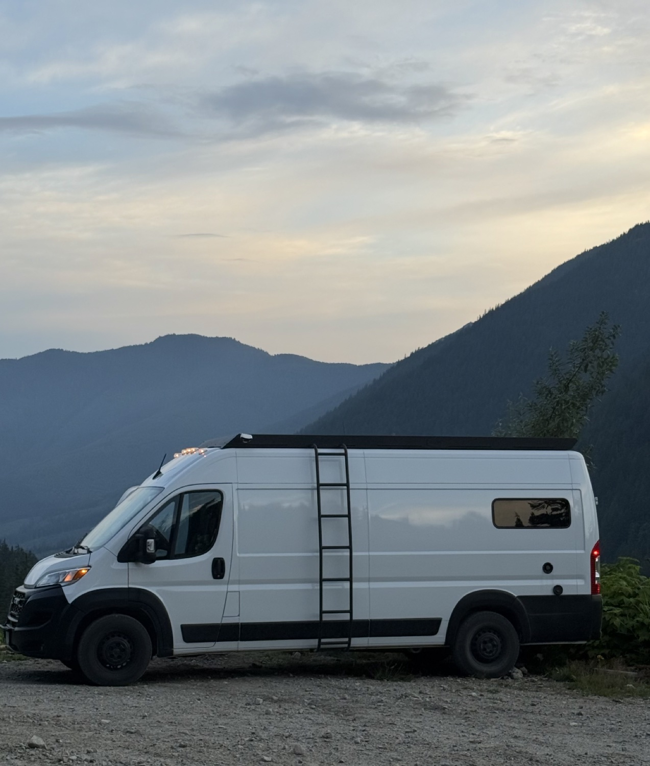 Zoe and Max's white Promaster van in the mountains
