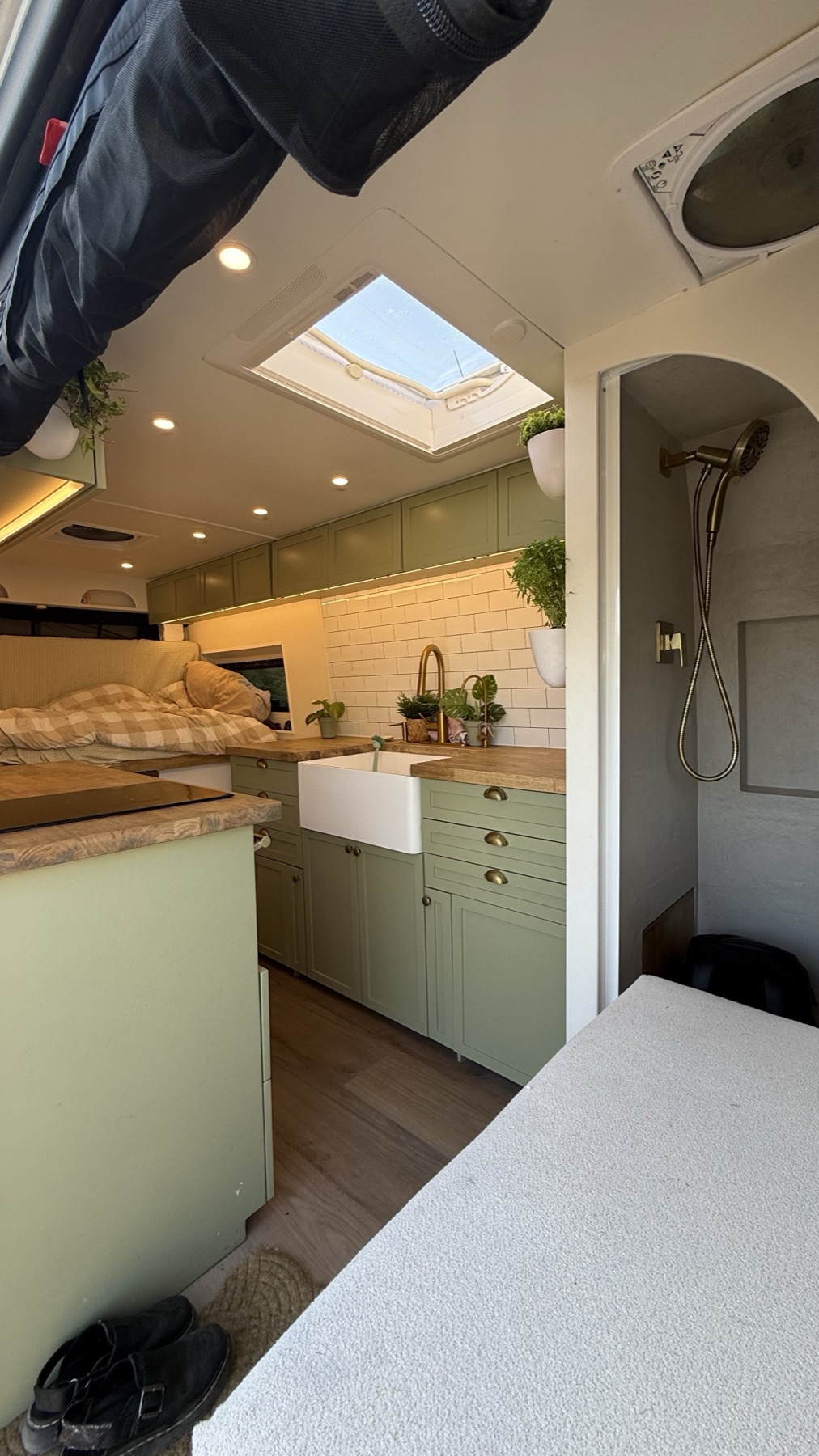 Van interior with skylight, kitchen, bed and compact shower